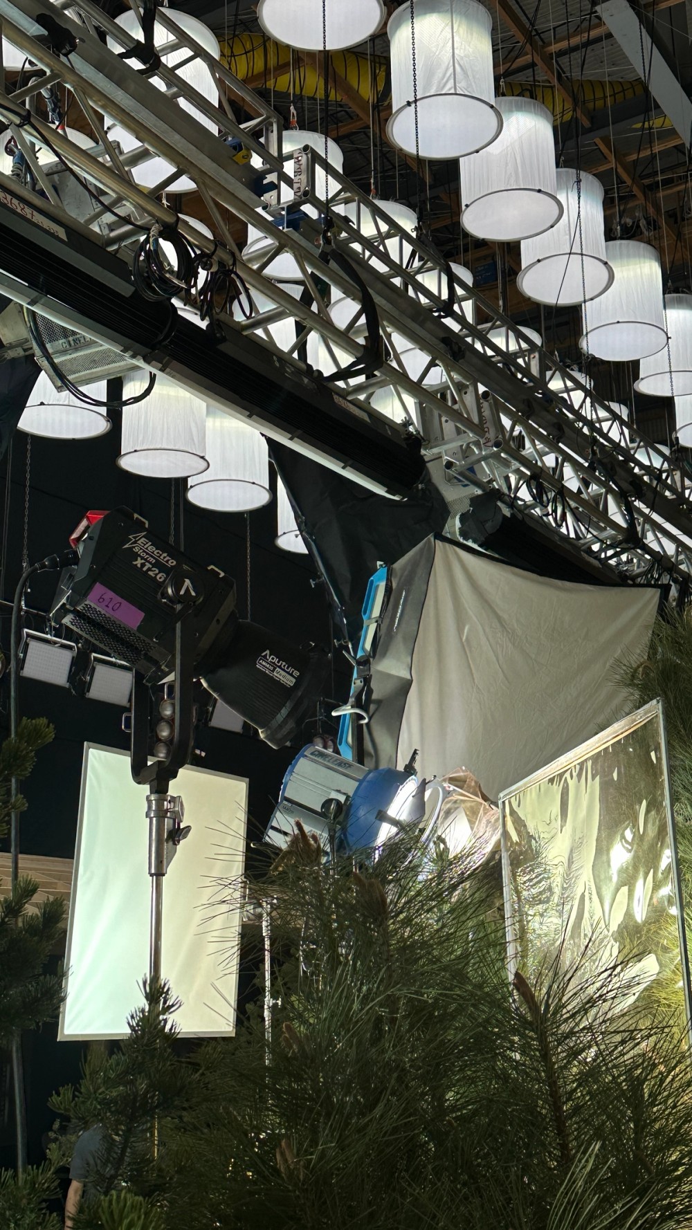 An Electro Storm XT26 shines through foliage and a Lightbridge frame on stage